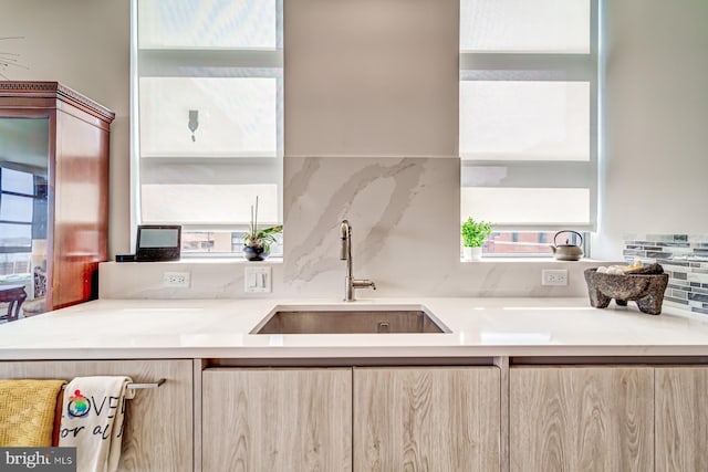 kitchen featuring decorative backsplash, light brown cabinets, and sink