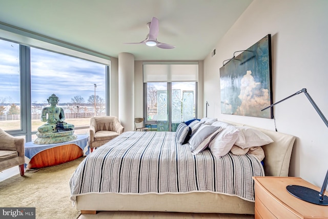 bedroom with ceiling fan and expansive windows