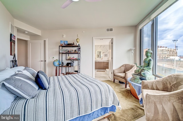 bedroom featuring ensuite bathroom, ceiling fan, and light carpet