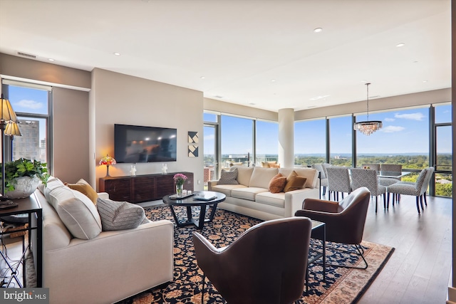 living room featuring a notable chandelier, a wealth of natural light, and hardwood / wood-style floors