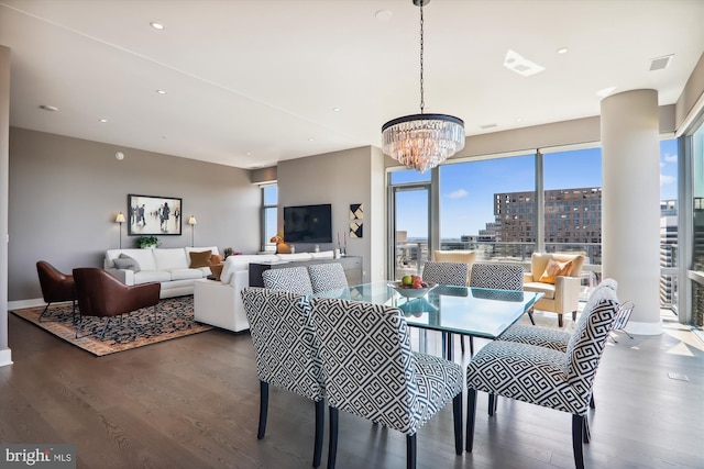 dining space featuring a healthy amount of sunlight, dark hardwood / wood-style floors, and a chandelier