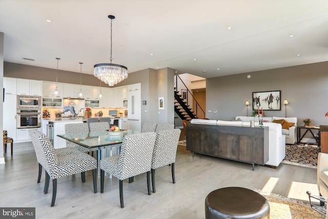 dining area with an inviting chandelier and light wood-type flooring