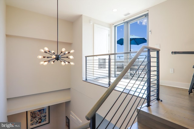 staircase with a chandelier