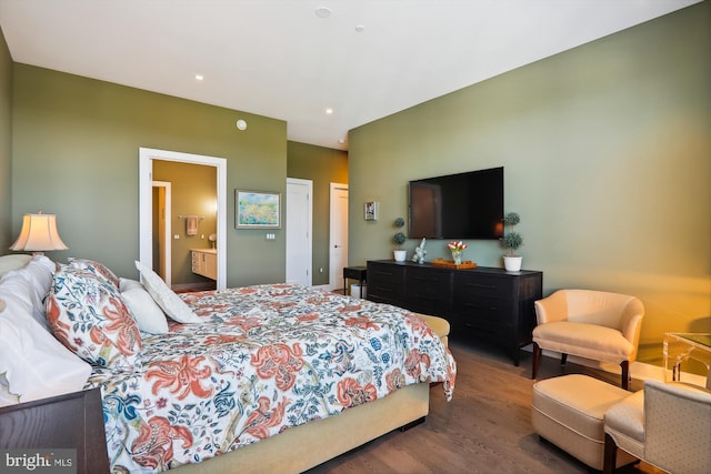 bedroom with ensuite bathroom and dark hardwood / wood-style floors