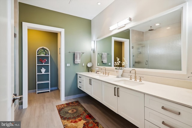 bathroom featuring an enclosed shower, vanity, and hardwood / wood-style flooring