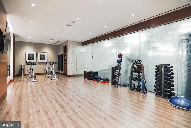 exercise room with light wood-type flooring