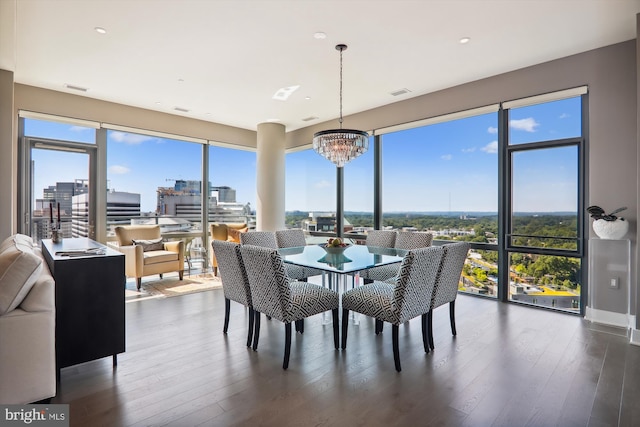 dining space featuring dark wood-type flooring, plenty of natural light, and an inviting chandelier