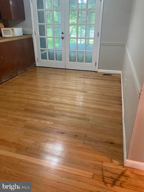 interior space with light wood-type flooring and french doors