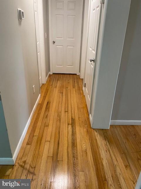 hall featuring light wood finished floors and baseboards