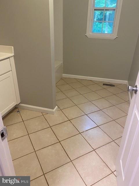 bathroom featuring vanity, tile patterned floors, and a bathtub