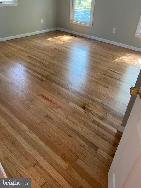 unfurnished room featuring baseboards and wood finished floors