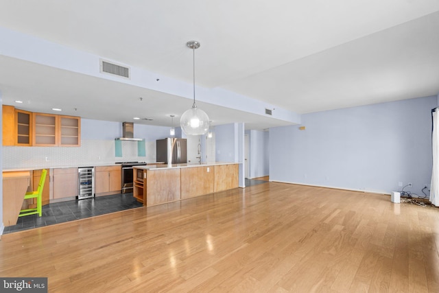 unfurnished living room with wine cooler and light hardwood / wood-style flooring