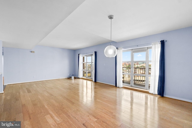 empty room with a healthy amount of sunlight and light hardwood / wood-style floors