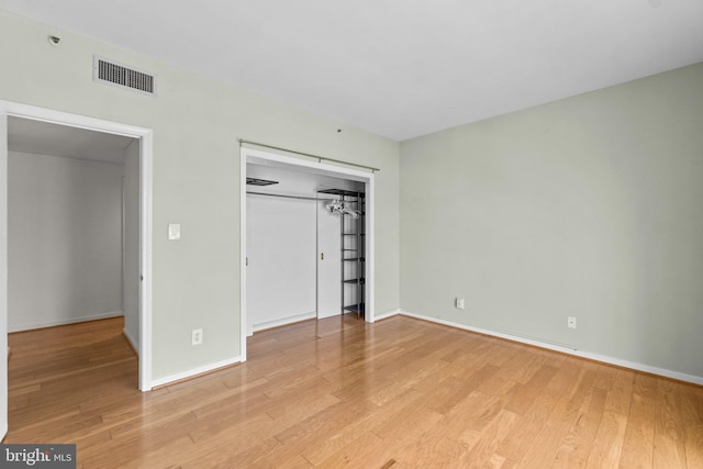 unfurnished bedroom with light hardwood / wood-style flooring and a closet