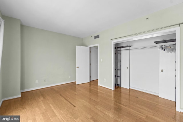 unfurnished bedroom featuring a closet and light wood-type flooring