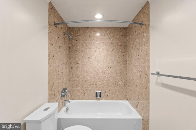 bathroom featuring toilet and tiled shower / bath combo