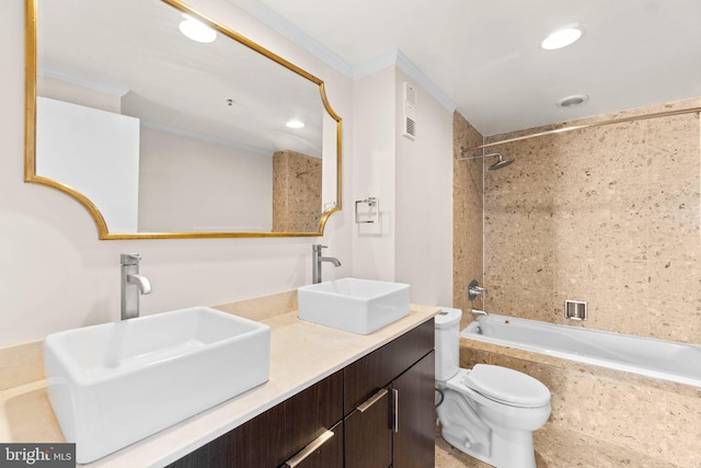 full bathroom featuring tiled shower / bath combo, vanity, crown molding, and toilet