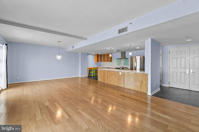 unfurnished living room featuring sink and hardwood / wood-style floors