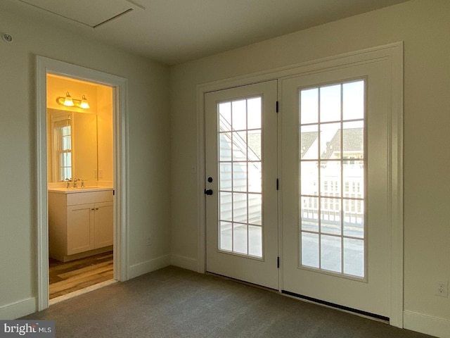 doorway featuring light colored carpet and sink