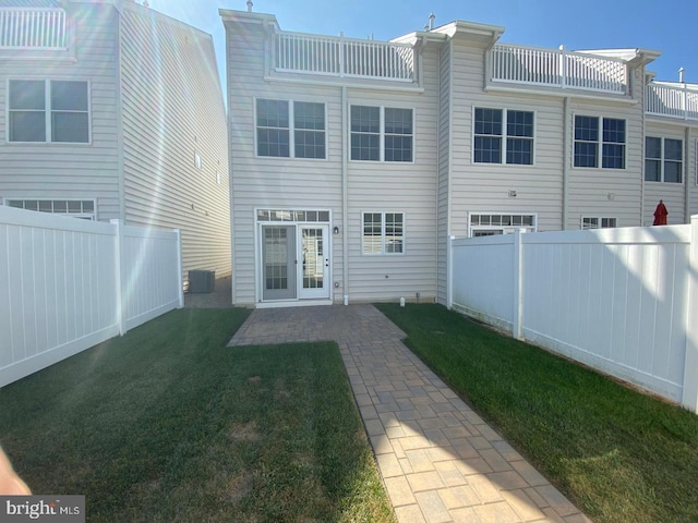 back of property featuring a lawn and a patio