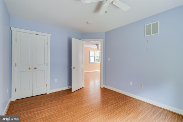 unfurnished bedroom featuring ceiling fan, a closet, and light hardwood / wood-style flooring