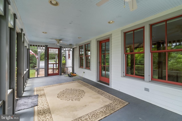 unfurnished sunroom featuring ceiling fan