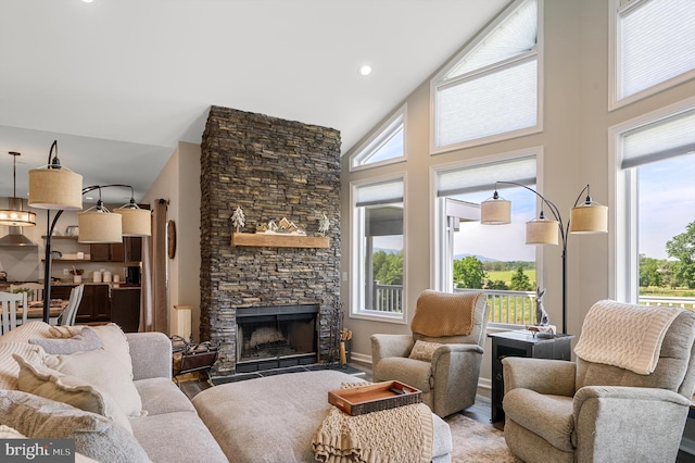 living room featuring a fireplace, high vaulted ceiling, and a wealth of natural light