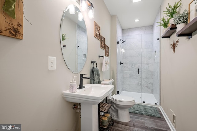 bathroom featuring toilet, wood-type flooring, and a shower with door