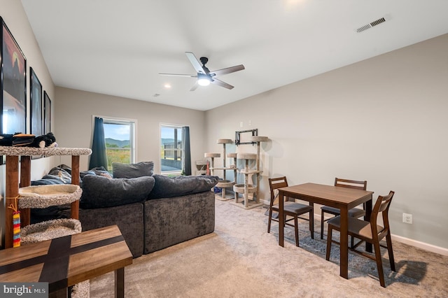 carpeted living room with ceiling fan