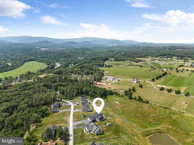 birds eye view of property with a water and mountain view