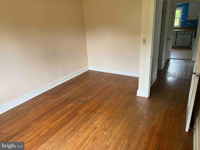 unfurnished room with dark hardwood / wood-style flooring