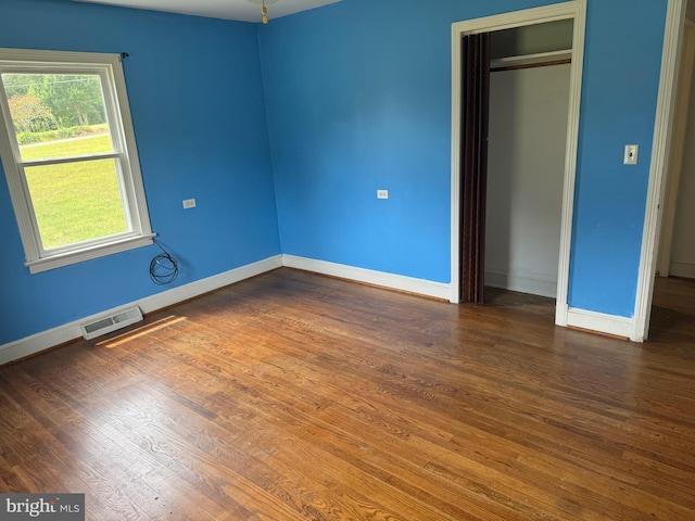 unfurnished bedroom with dark wood-type flooring and a closet