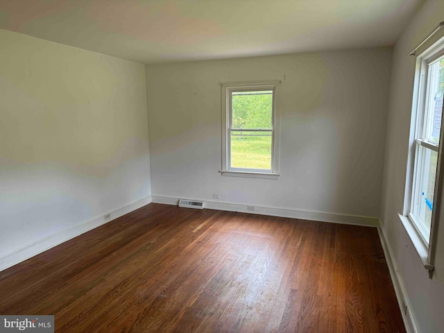 empty room with dark hardwood / wood-style flooring