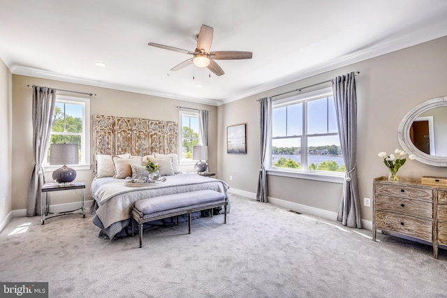 bedroom featuring a water view, crown molding, and light carpet