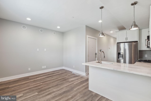 kitchen with sink, wood-type flooring, stainless steel appliances, and white cabinets