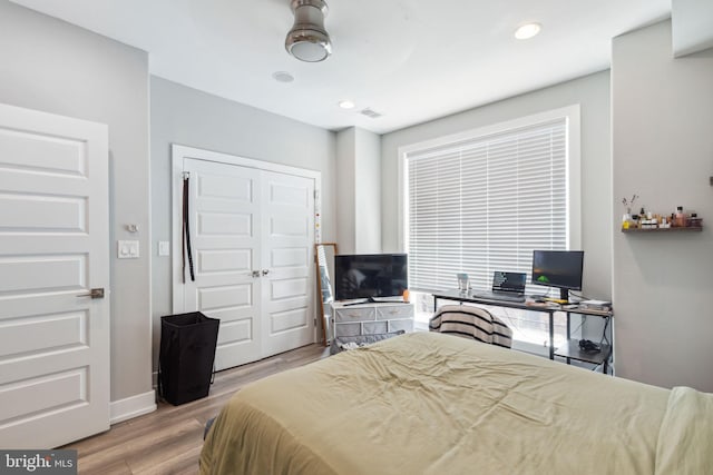 bedroom with ceiling fan, light wood-type flooring, and a closet