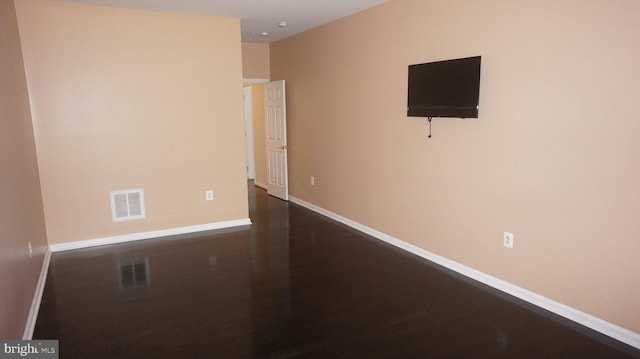 unfurnished room with dark wood-type flooring