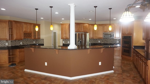 kitchen with a breakfast bar, pendant lighting, stainless steel appliances, and ornate columns