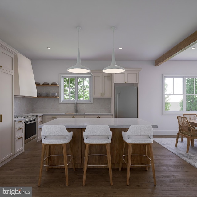 kitchen with stainless steel refrigerator, sink, backsplash, a center island, and custom range hood