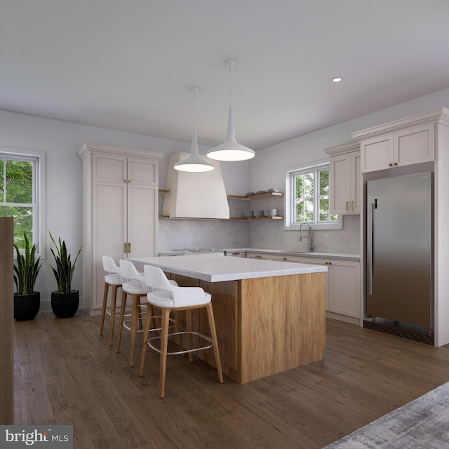 kitchen with backsplash, stainless steel fridge, a center island, and white cabinets