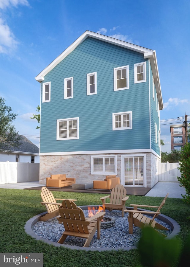 back of property featuring a yard, a fire pit, and a patio