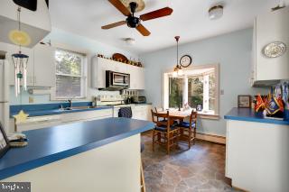 kitchen featuring decorative light fixtures, dark tile patterned floors, and ceiling fan