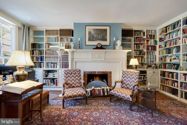 living area featuring a fireplace, hardwood / wood-style flooring, and a baseboard heating unit