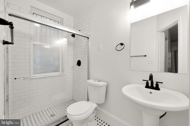 bathroom featuring a shower with shower door, toilet, tile patterned floors, and sink