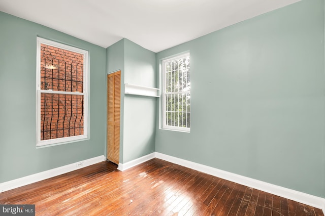 unfurnished room with hardwood / wood-style flooring