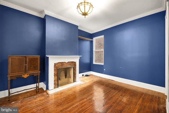 unfurnished living room with hardwood / wood-style floors, a high end fireplace, and ornamental molding