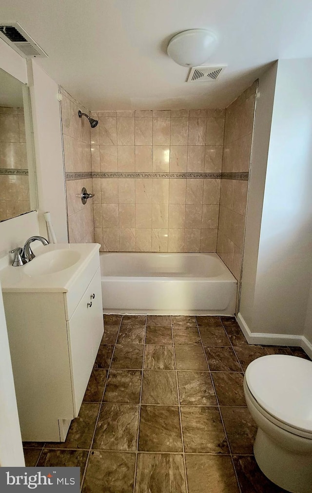 full bathroom with tiled shower / bath combo, vanity, and toilet