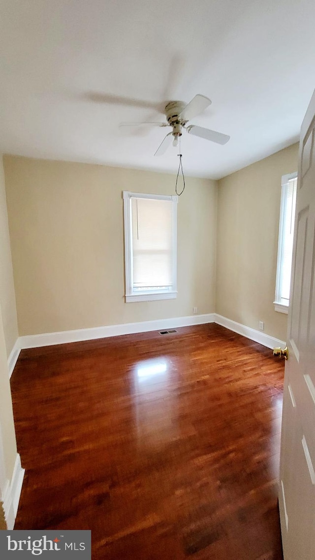 unfurnished room with ceiling fan and dark hardwood / wood-style floors