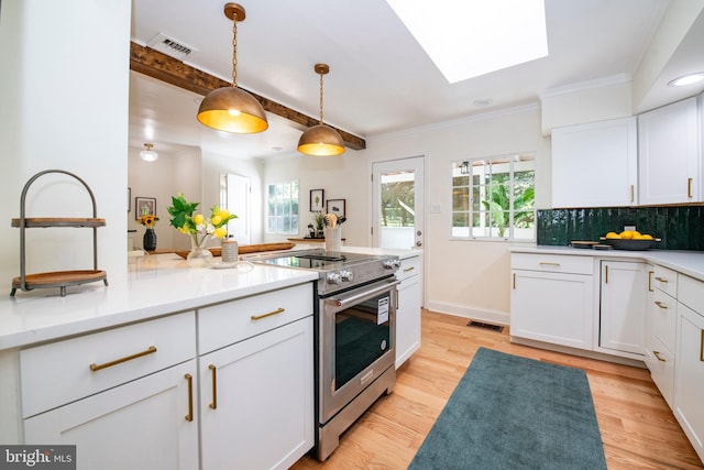 kitchen with electric stove, light hardwood / wood-style flooring, white cabinets, and pendant lighting