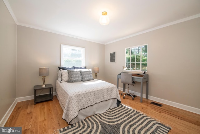 bedroom featuring crown molding and light hardwood / wood-style flooring